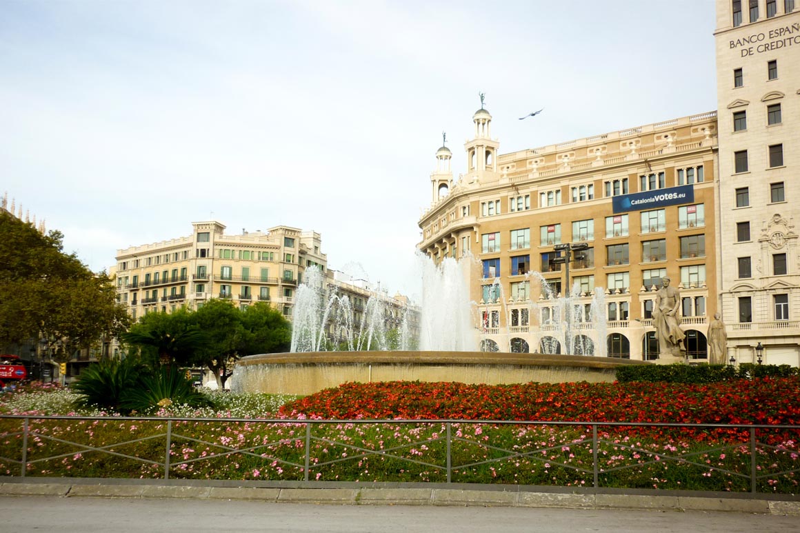 Praça da Catalunha Barcelona com flores e chafariz em primeiro plano
