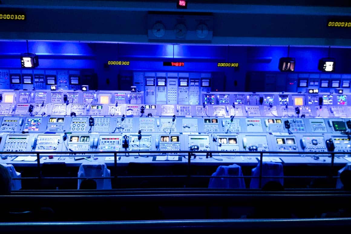 Simulação da sala de controle das missões Apollo no Apollo/Saturn V Center. Consoles originais com luzes acesas e painéis de instrumentos durante contagem regressiva de lançamento