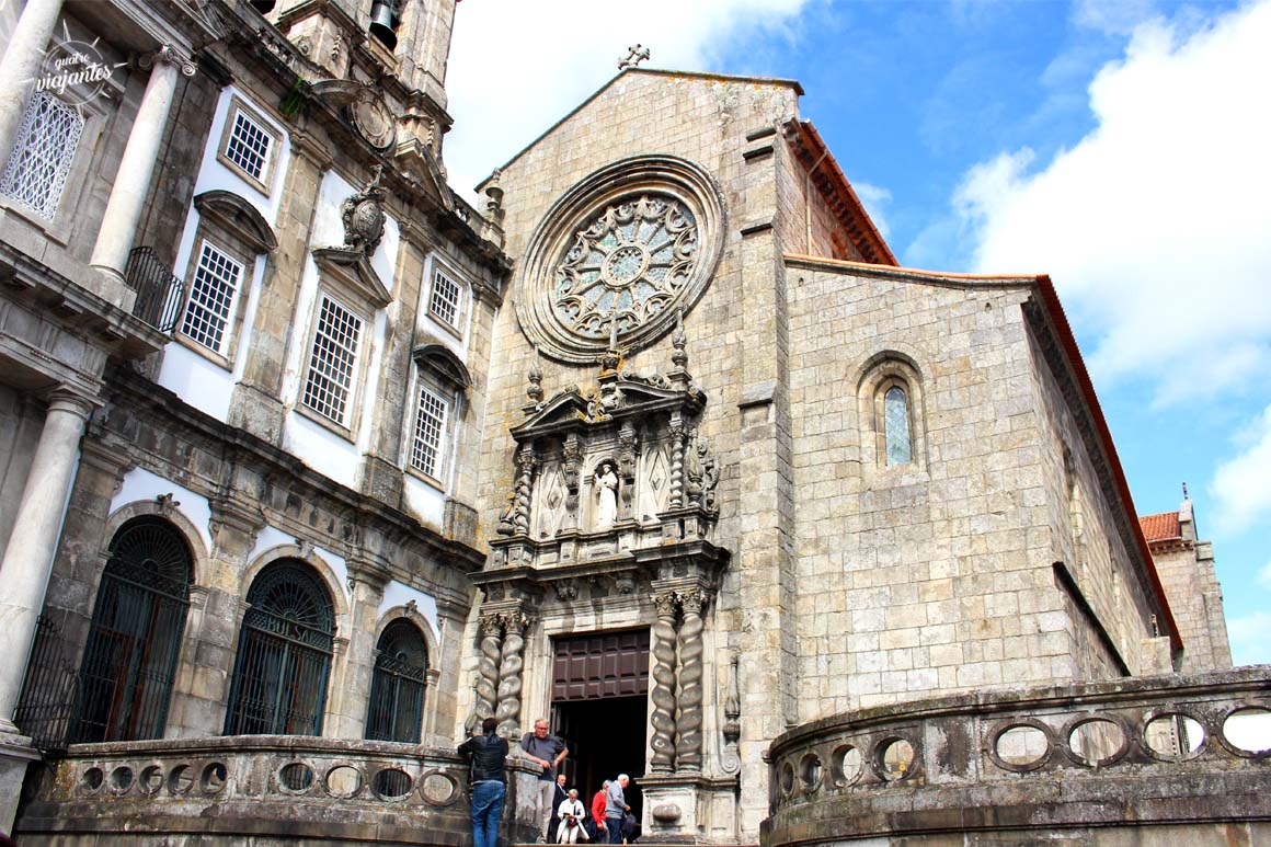 Fachada gótica da Igreja de São Francisco no Porto com arco ogival decorado e edifícios históricos ao redor em dia claro