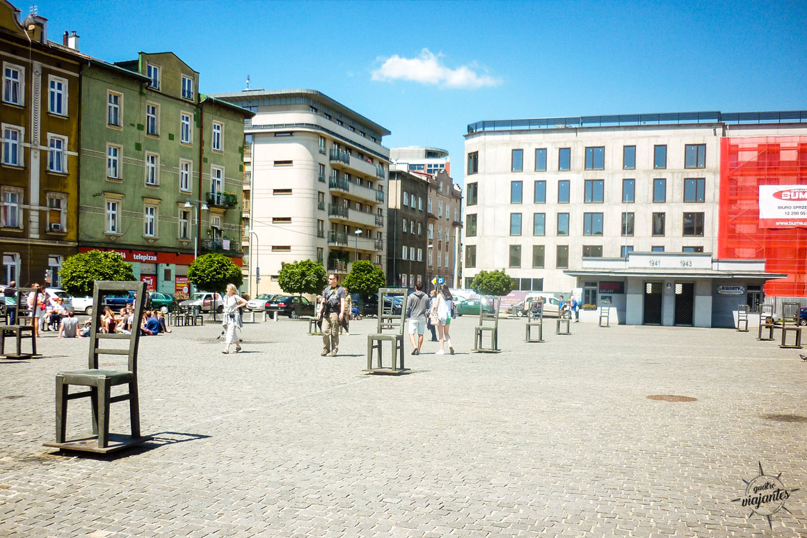 Praça dos Heróis do Gueto (Plac Bohaterów Getta) em Cracóvia, instalação artística com cadeiras de ferro vazias simbolizando deportações judaicas para Auschwitz durante a Segunda Guerra, memorial silencioso no antigo local do gueto na capital medieval polonesa.