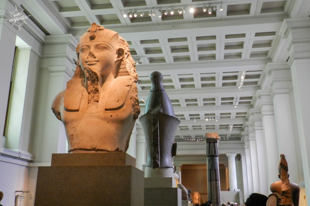 Sala do Egito Antigo no British Museum, Londres: Roseta Stone, estátuas de Ramsés II e sarcófagos sob iluminação com visitantes