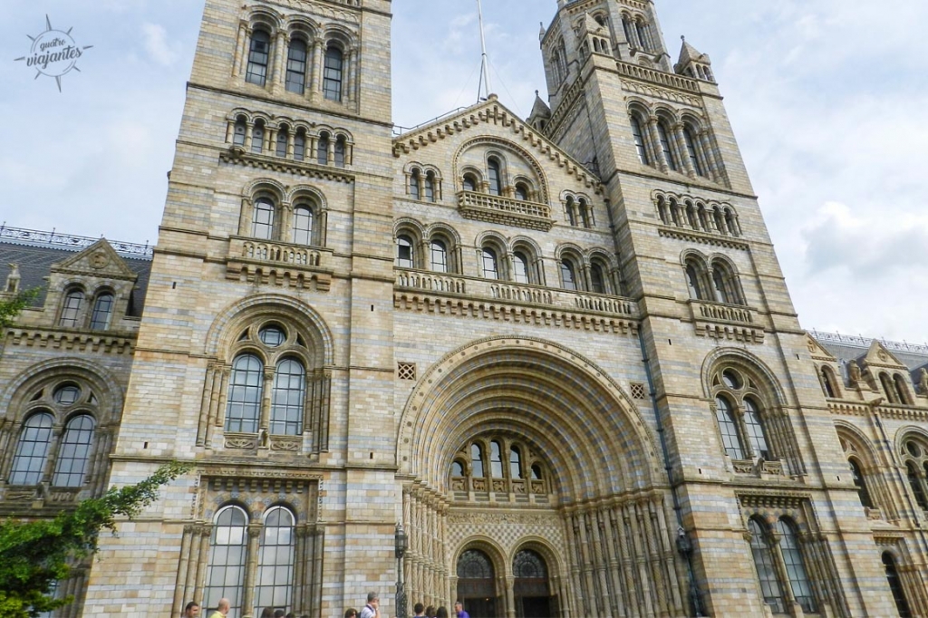 Fachada românica imponente do Museu de História Natural em Londres, com torre central, arcos ornamentados e detalhes em terracota no bairro de South Kensington. Uma das atrações grátis em Londres.