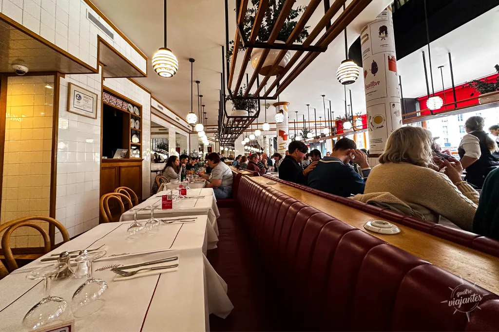 Interior lotado Bouillon Pigalle Paris na hora do almoço: mesas brasserie com pratos franceses clássicos, garçons e clientes em ambiente animado bistrô