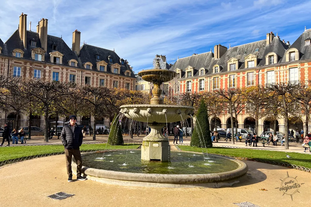 En frente ao chafariz da Place des Vosges, a primeira praça planejada de Paris