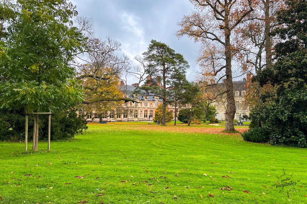 Jardim do Castelo de Fontainebleau, com árvores e edifícios.