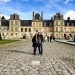 Castelo de Fontainebleau França, casal viaja pelo pátio principal em dia ensolarado