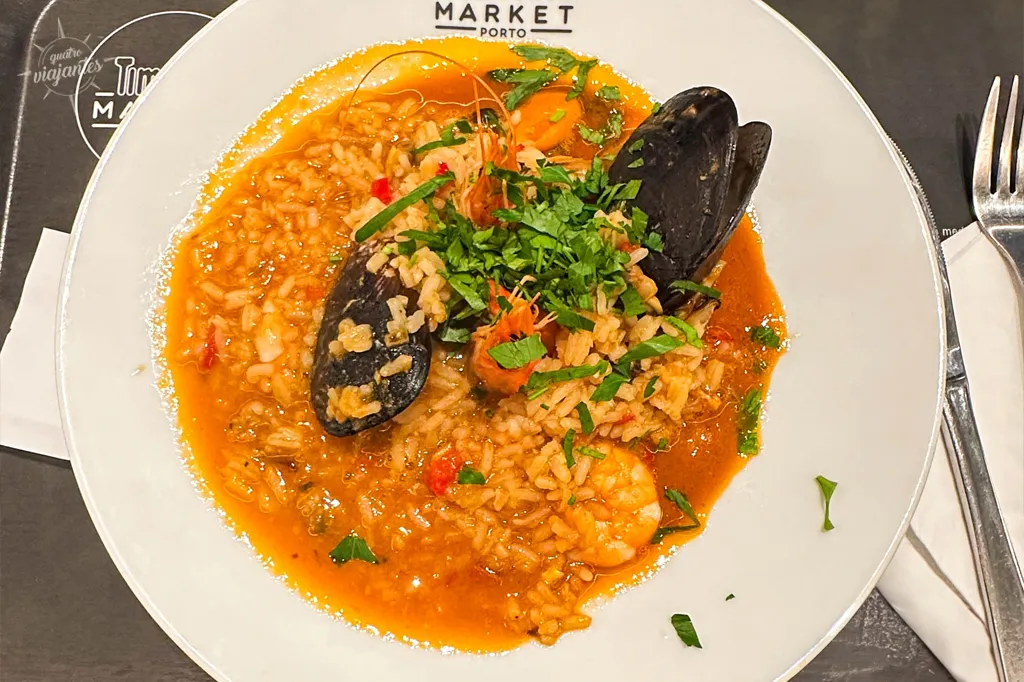 Arroz de marisco fumegante servido no Restaurante Meia-Nau, no Time Out Market da Estação São Bento no Porto, com mariscos frescos, arroz soltinho e caldo rico, prato assinatura do chef Ivo Ferreira. 
