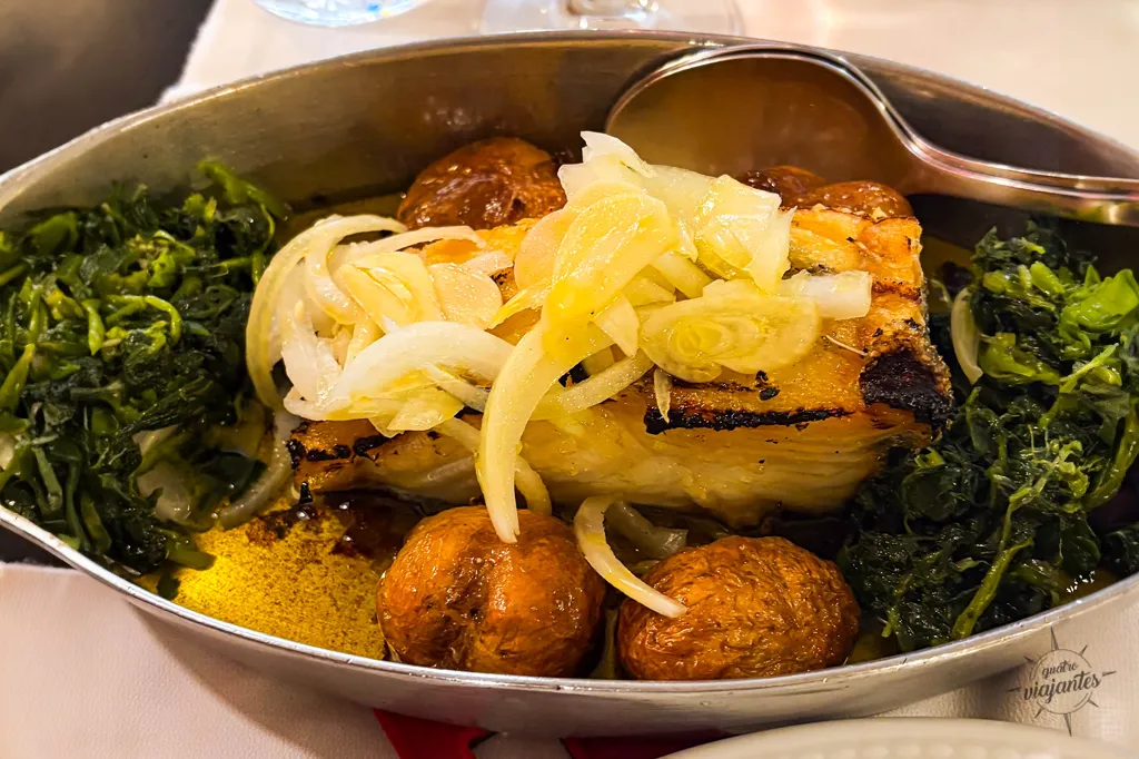 Bacalhau à João do Porto servido no Restaurante O Bacalhoeiro em Vila Nova de Gaia, com lombo grelhado generoso regado a muito azeite, acompanhado de batatas cozidas, ovos, cebola refogada e azeitonas, às margens do rio Douro.