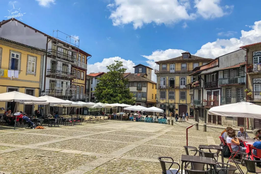 Largo da Oliveira em Guimarães com chafariz histórico e cafés, Portugal