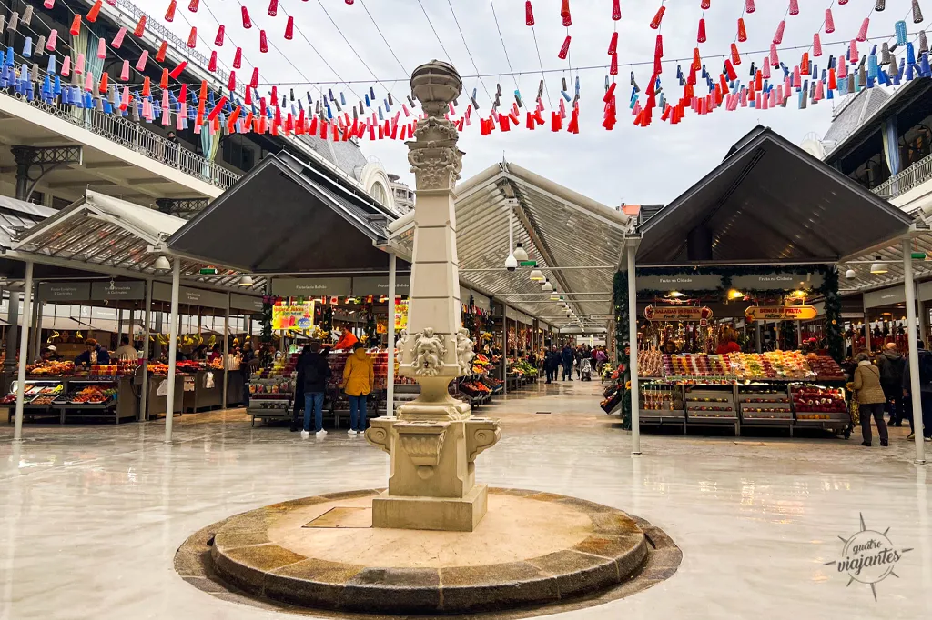 Entrada do Mercado do Bolhão no Porto com estrutura metálica e quiosques de produtos típicos portugueses.