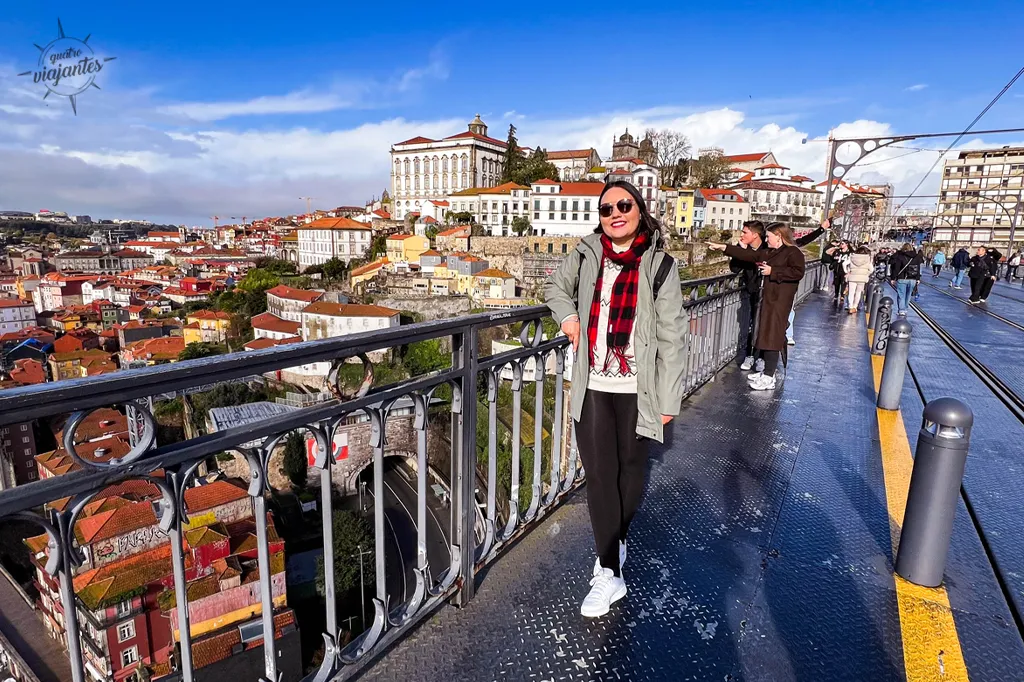 Passarela superior da Ponte Luís I com pedestres caminhando, trilhos do metrô e vista ampla do Rio Douro e edifícios ribeirinhos
