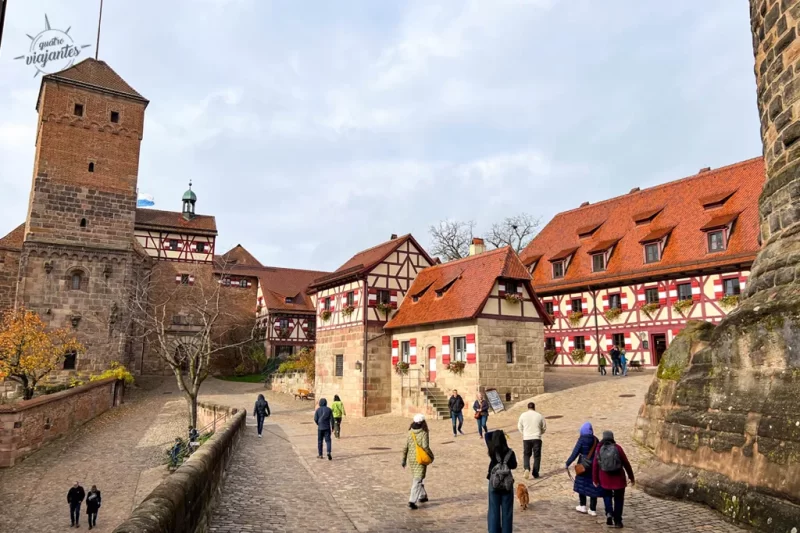 Castelo Imperial de Nuremberg (Kaiserburg) no topo de colina de arenito: muralhas medievais, torres como Sinwellturm, pátios e vista panorâmica da cidade antiga com telhados vermelhos. É exemplovda Nuremberg medieval.