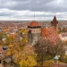 Panorama de outono em Nuremberg com torres do Castelo Imperial, muralhas antigas, telhados vermelhos e folhagem amarela