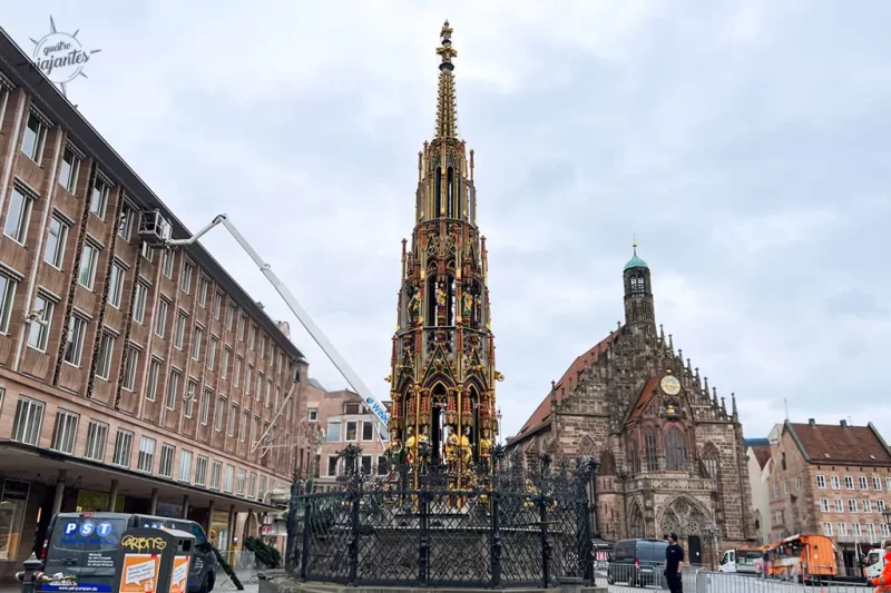 Fonte Schöner Brunnen (Fonte Bonita) no Hauptmarkt de Nuremberg, Alemanha: torre gótica de 19m com 40 figuras esculpidas policromadas, pináculos e grades com anel giratório dourado